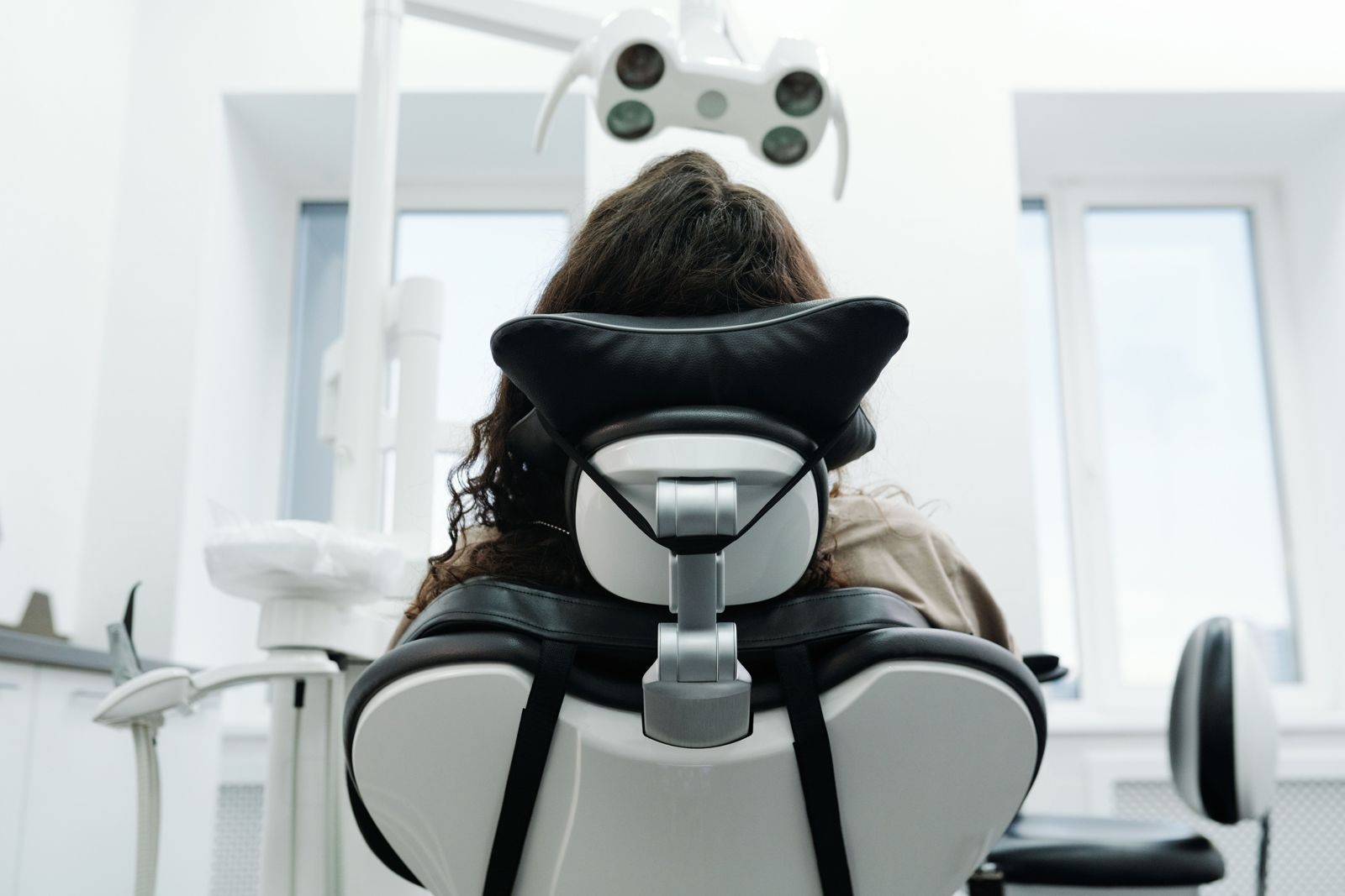 Rear view of a person resting against a padded contoured headrest on a reclining seat