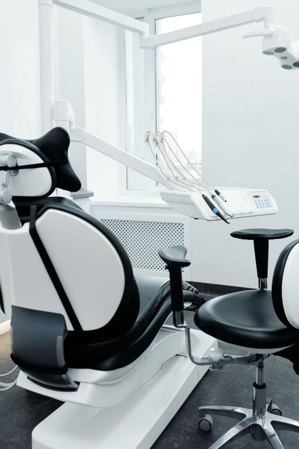 Black and white reclining seat with contoured headrest and adjustable arm in a bright room